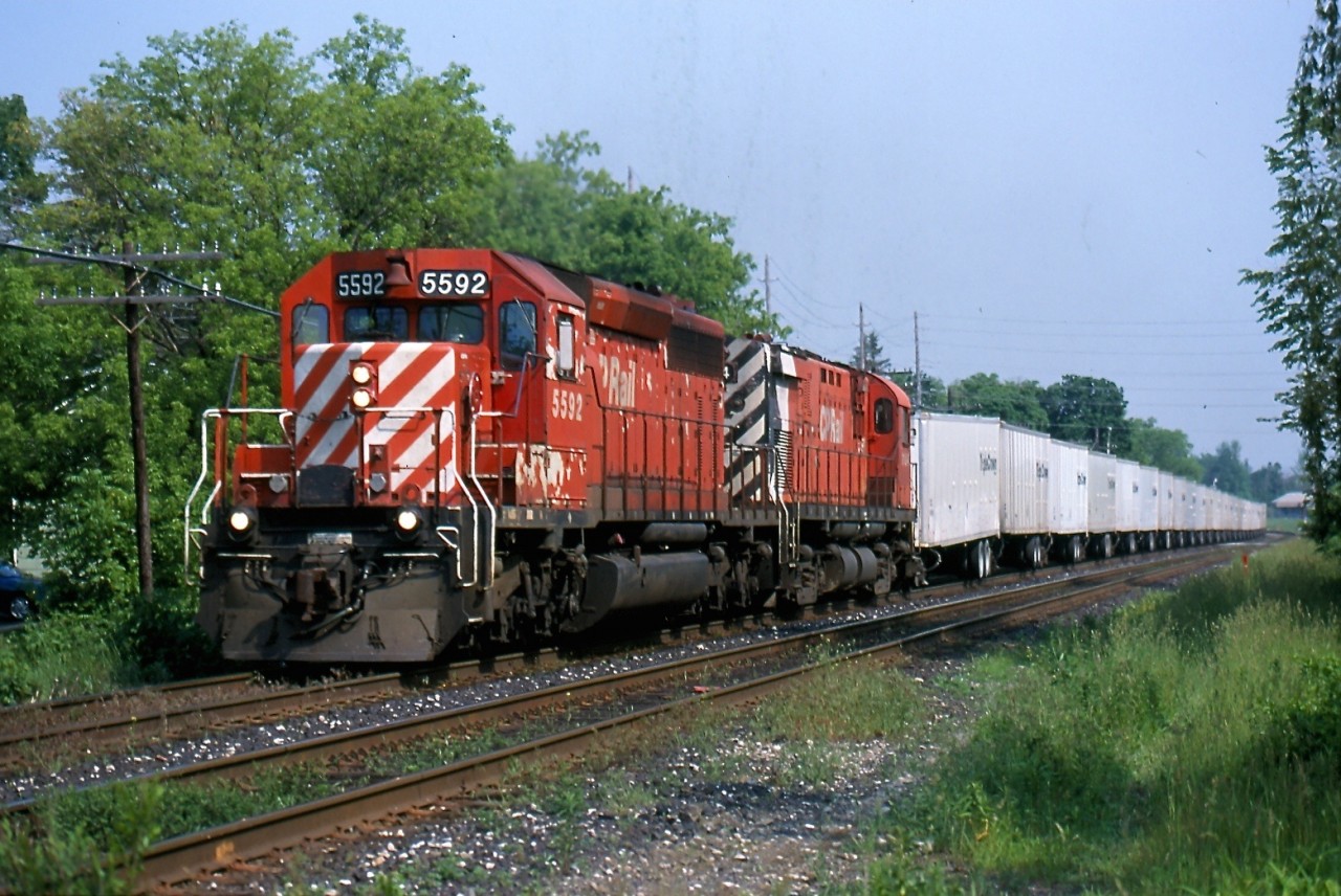 Catching the Triple Crown Roadrailer on CP was once such an easy task. It was typically a mid to late afternoon westbound often on the block of the "Sprint" frame train. A trio of SD40 mothers and C424 control cabs rotated daily on the train. That was until CN took over the operation between Toronto and Detroit. Here we have the westbound Roadrailer passing through Streetsville back in 2000.