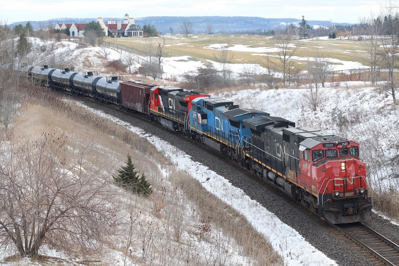 A mixed bag of GE built locomotives, including a Dash-9 from CN's first order, a former LMSX  Dash-8 and a former UP, nee CNW standard cab Dash-8. This is an eastbound crude oil train off the BNSF. The shot is off the golf course bridge north of Milton with the mansion like golf course clubhouse in the background.