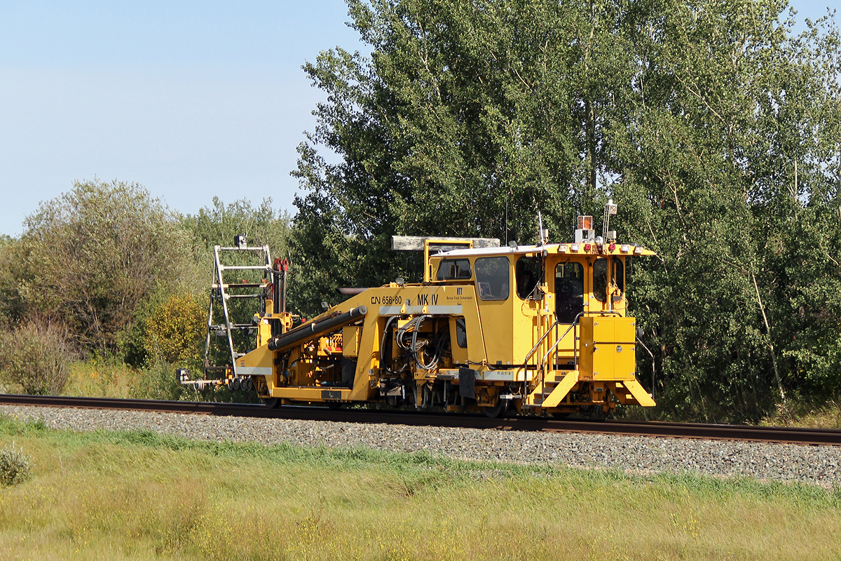 Harsco Mk IV tamper CN 656-80 scurries east past North Cooking Lake, probably close to or at its maximum travel speed of 48 km/h.  It has another 7 miles to Lindbrook before it can move out of the way for other traffic.