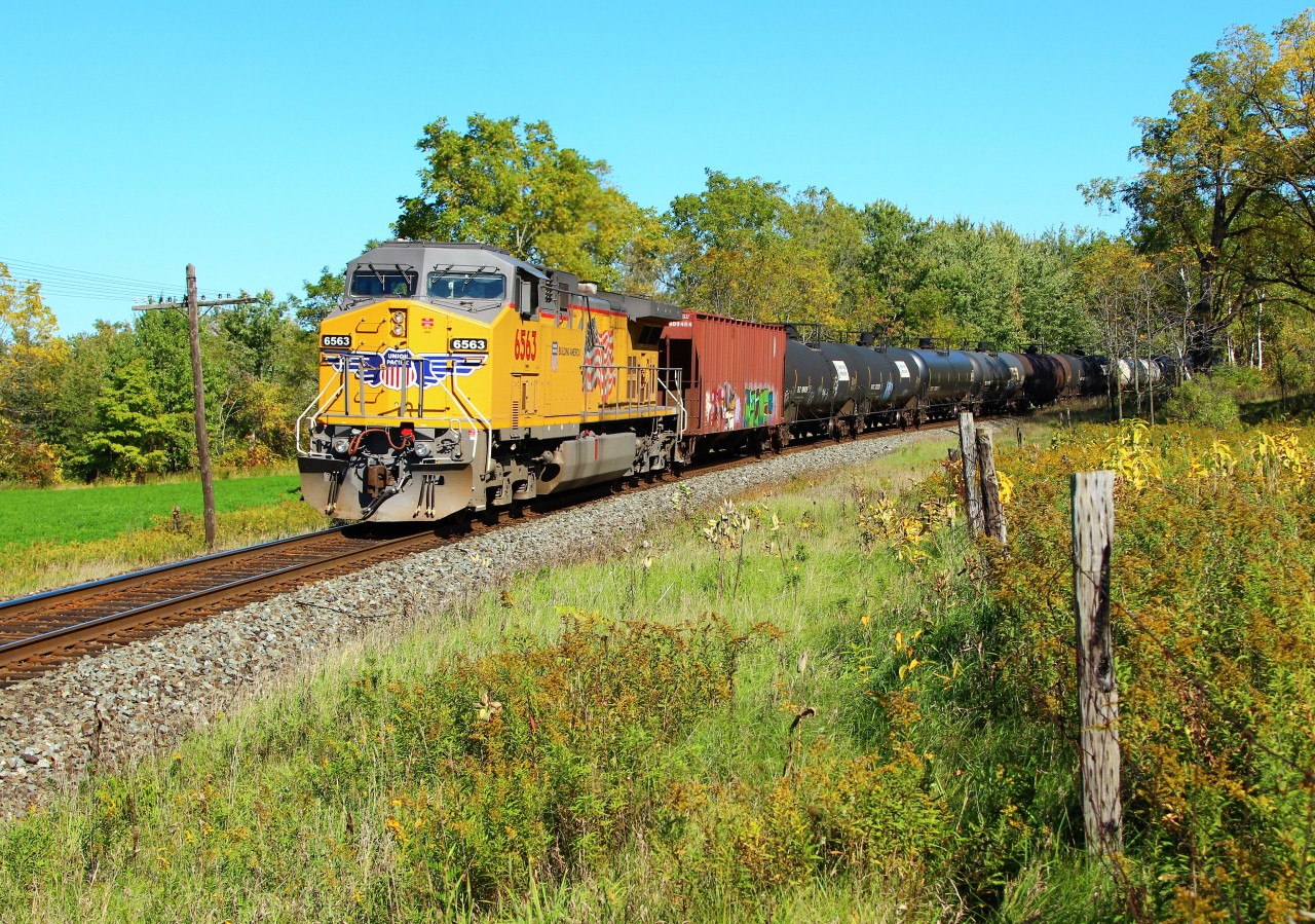 After waiting quite a while for UP 5539 to show from Wolverton, the lead engine turned out to be a little disappointing. A badly faded and single UP 5539 was leading the 6000 foot ethanol train eastbound across Victoria Road, so as is often the case, I was hoping for a descent DPU. I was shooting from in the field for a better sun angle for an eastbound, so after a near 50 yard sprint across the field, I made it to this location for a better sun angle, and a nice clean, bright UP 6563 was doing the pushing. Got lucky!!