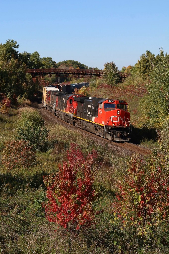 When I started railfanning back in the mid 1990s this location quickly became a favourite of mine. A group of us nicknamed "the Georgetown Railfan Society:) would often spend the afternoon noon here. Before the ritzy golf course took over the parallel land anyone could hike in here, hop the fence and get great shots in both directions all afternoon. Today I rarely venture in and shoot here mainly as it is overgrown and I don't want to scare off the golfers :) The bridge has taken a bit away from the shot too but in the fall the colour is still quite decent here. This past Friday I fought my way through the waist high weeds to catch CN 435 with a trio of older GE built units. I still love this place and the memories it holds.