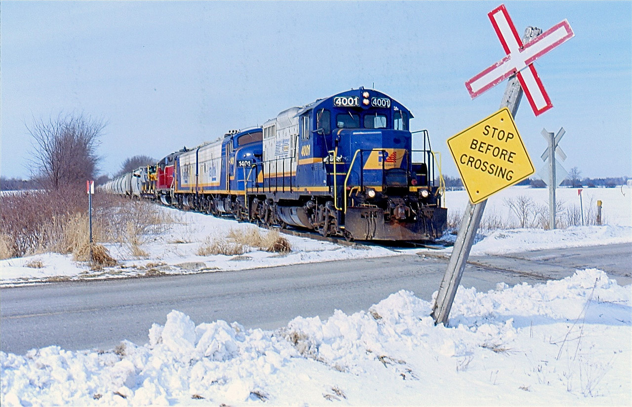 EMD's 567 prime mover has long been at home on the former CN Goderich subdivision. GP9s and "F" units have called this line home for decades. Some units have worn CN paint, others Goderich-Exeter and Railtex paint. By the mid 2000s Railink blue and cream dominate much of the GEXR trains on the line. Here we see train 581 rolling eastbound out of Goderich passing a cross buck that has seen a lot of action from the number of road plows have past through. This power set was very common for a good portion of the 2000s until the "F" units were stored for good :(