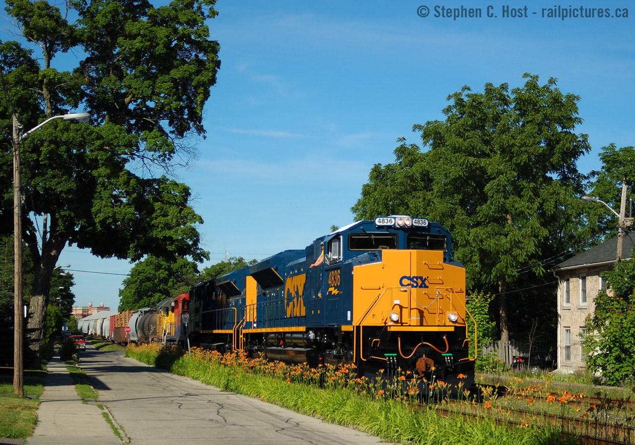GEXR in Summer 2004 could be described as follows: Shiny. Most days new engines from EMD would end up on the point of 431 and 432, mostly CSX SD70ACe's - but there were CN, BNSF and even Union Pacific ACE's all fresh from EMD London. (The UP run would happen AT NIGHT and only happened ONCE that I am aware of!). Living at Kent St at this time in my life had its benefits - close to downtown (bars!) and close to tracks. A few friends joined me beers in hand while we watched the train go by - and I was smart enough to take my camera out for one of my few actually half decent photos of these movements. The time was 17:50.
Rob Smith would certainly note - There was always a smoky joe on the train through Guelph - in this case an EMD employee who ALWAYS took his smoke break on cue for the ride down Kent St. EMD employees rode along as part of these tests which lasted from July 3 2004 into October 2004. A CN -M2 unit also tested to Tornto on GEXR in January 21 2006 so tests weren't exclusive to just the summer '04 period. There were also numerous tests between London and Stratford which I regrettably never went to see, someone will share here some day i'm sure :) The beauty of our hobby.