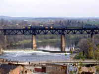 VIA Rail train #81 crosses the high bridge over the Grand River at Paris, in April 1979, lead by an A-B-A consist of an FPA4, F9B and FP9. Still relatively early in the VIA era, some of the passenger cars retain CN's black and white livery, not yet repainted blue and yellow.
