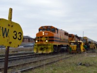 GEXR 582 rolls into the weed-covered XV yard in Guelph with 8 empty center beam flats from Hunt's Haulage for GEXR 580.