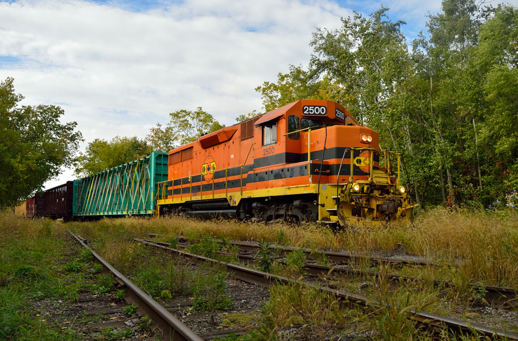 GEXR 582 rolls into the weed-covered XV yard in Guelph with 8 empty center beam flats from Hunt's Haulage for GEXR 580.