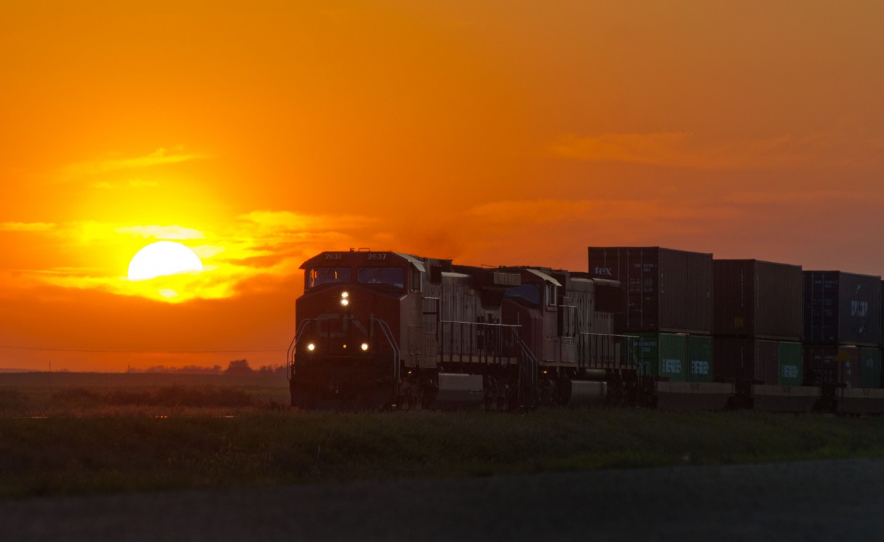 One of the best thing's about rail fanning in the prairies is the ability to shoot from sunrise to sunset with no obstructions on the horizon (i.e. mountains). It's 20:02 and the prairie sun is not far from ending another day. In the foreground an eastbound CN intermodal is seen passing through Allan SK.