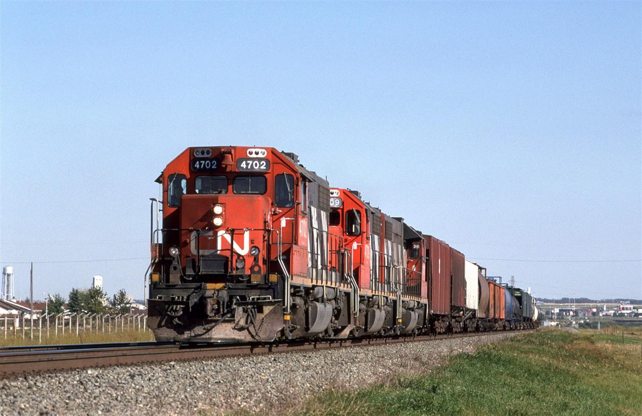 CN's Brazeau Sub local returns to Edmonton in the early evening. 
I can't be certain, I but I believe that this train was an out-one-day-and-return-the-next operation. 
It may be difficult to determine from the resolution of the photo, but that blue tank car, seven cars back, is an eight axle monster. I would see these on this train periodically (but never noticed them on any other train). Their destination was the Union Carbide (now Dow Chemical) plant at Prentiss.
I would see these cars again, along with six axle tanks on UP's Angleton Sub south of Houston in the mid 2000's.