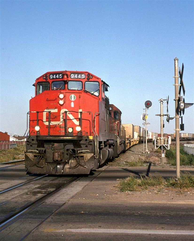 Train 201 crosses the level crossing at 50th Street in NE Edmonton. In a few years, a bridge would be built  and the road would pass under the tracks.