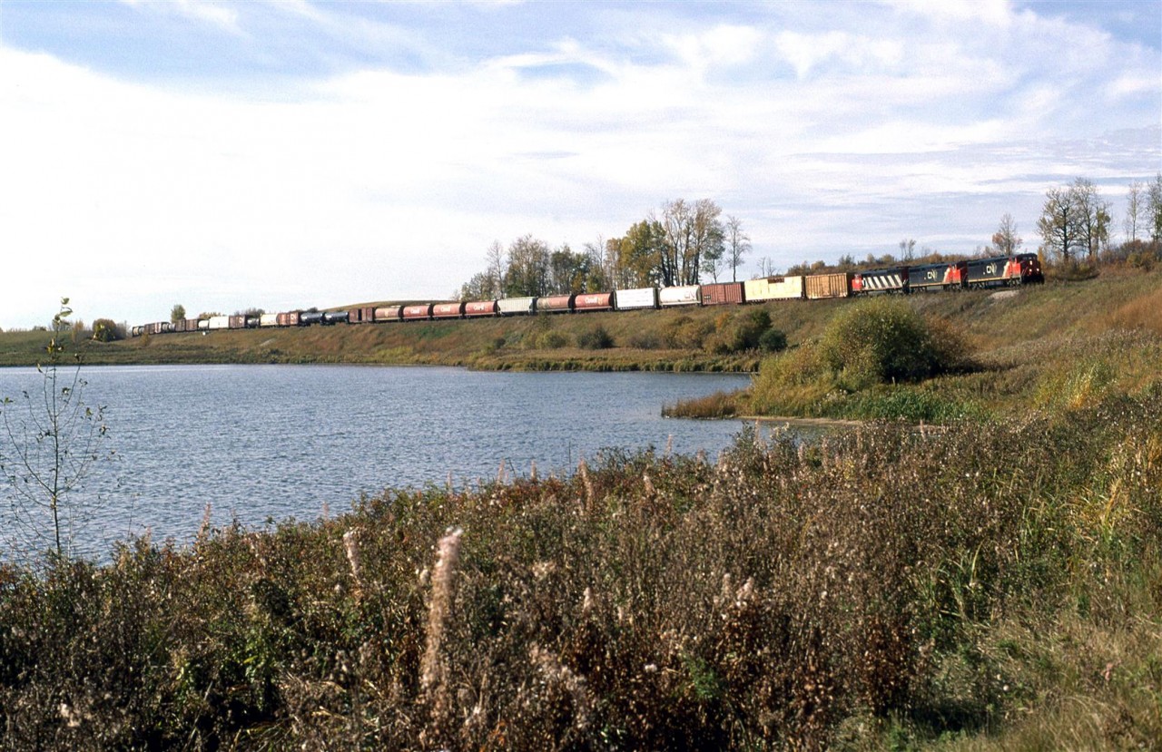 Two GE's wearing the CN "paint chip" North America paint scheme and a SD50 in the last of the stripes scheme lead this eastbound manifest around the Carvel curves and Mink Lake.