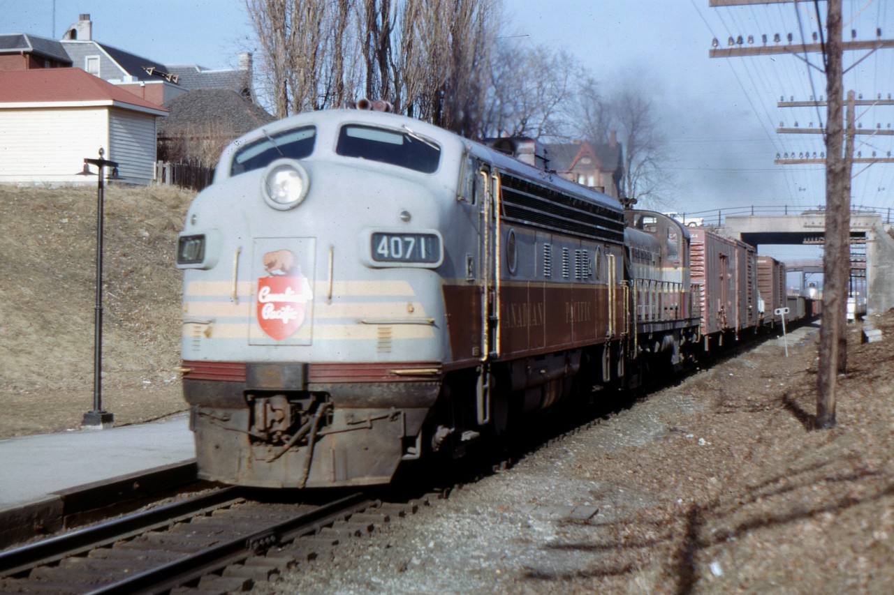 CP train 903 has just passed under Simcoe Street in Oshawa led by FP-7 4071 and RS-2 8407 on March 16, 1966. The Simcoe Street overpass was built for two tracks and the extra space can be seen to the right of the train. The second track was never installed but current plans for GO train expansion to Bowmanville will make use of this hundred year old "future" planning.