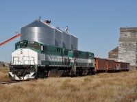 Driving east along Hwy 13 in southern Saskatchewan, I looked over to the south as thee were a couple of old grain elevators in the distance. And, somehow, from about 2 KM away I picked out what looked to be an engine, rather than the usual grain cars. Talk about luck!!! The hamlet of Horizon is something else. The two existing grain elevators are historically unusual, and the "town" is reduced to a church, perhaps closed, and a couple of houses by the look of it. Might be 10 people there, all told; for it lost its status as a community more than 40 years ago. A Saskatchewan ghost town!! The road in is rough gravel, and the main introduction to the place is a decrepit old shack at the first intersection, surrounded by weeds and neglect. When checking google maps I found it rather hard to believe the drive up to the elevators off the "main road" actually qualified as streets and were given names. And it was very surprising to see a ballast train of the Great Western Rwy to be parked on the siding here; as this is actually trackage of the Red Coat Road & Rail. This is operated by the adjacent Great Western, but I noted a long line of stored cars had severed the two roads, so expected to find nothing but the Southern Prairie Rwy at nearby Ogema, which is a tourist operation and I thought it was now the sole reason for the Red Coats' existence. But the ballast trains' presence suggests a brighter future ahead. GWRS 2000 and 2002 with 5 cars of ballast await the start of the work week, nestled between two of the most unusual elevators I have seen in a while. (The other is to my back) This pair of M420s I suggest have very few years of service left. They were built in 1973 & 1974.