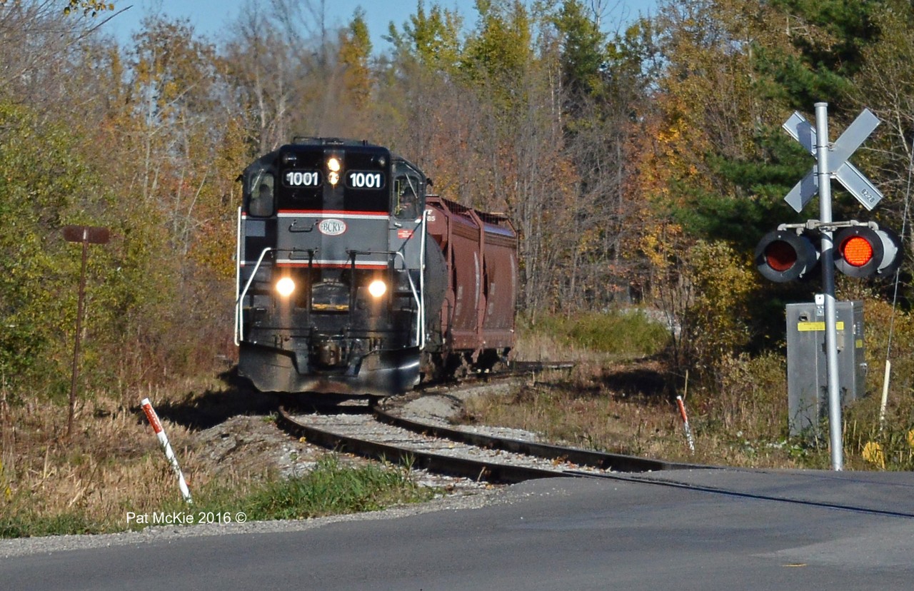 BCRY 1001 hauls its 4 car train across Huronia Rd in Barrie ON as 2 of the cars will be set off at a local industry in Innisfil and two will return and be set off to a local industry just North of the crossing at Huronia Rd (Crossing in photo)