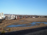 This is different. Initially I was not going to post this image, but I was convinced there may be a few of you out there in the Hamilton/Burlington area that might find this interesting. I am on the new Fairview Av overpass looking northwest. The old Burlington West CN station is in the center background, and the Hercules Chemical plant is on the left. The CN Oakville sub runs east-west in the background. "In front" of  the station is the former "yard"...there was a few industries there that were serviced by both CN and also CP, which had permission over CN into the diminutive yard. I forget whom they switched, but it probably was Hercules. You can see on the left of the photo the number of tank cars indicating they were an important customer of the railroads back then. The track that runs below me on the left is now only a stub, just enough for plant switching. The line used to run from the connection at Burlington West all the way down to Stoney Creek where it connected with the Grimsby Sub near Lake St. The line was severed around 1970 when the QEW Traffic Circle that it ran over top of, was removed. The line then ended at Lang's (Frozen) Foods. That building still stands by Confederation Park. The whole of the Beach line was removed by late 1983. In the foreground of this photo, almost dead center, stands the Mandarin Restaurant today. 