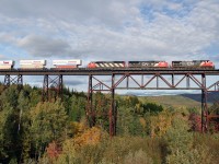   CN's Q120 stack train with CN 2649, CN 5764 and CN 5511 E/B crossing the long trestle bridge at St.Eleuthere, Québec on CN's Montréal-Halifax mainline; August 30, 2005