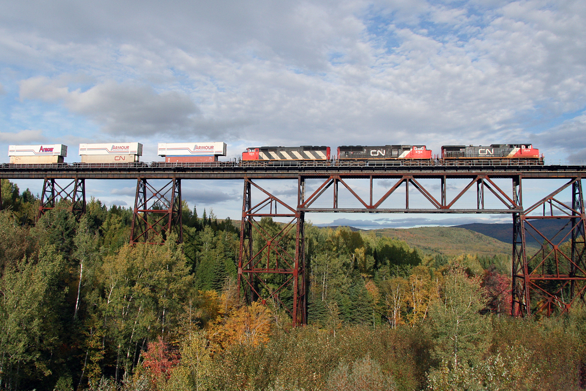 CN's Q120 stack train with CN 2649, CN 5764 and CN 5511 E/B crossing the long trestle bridge at St.Eleuthere, Québec on CN's Montréal-Halifax mainline; August 30, 2005