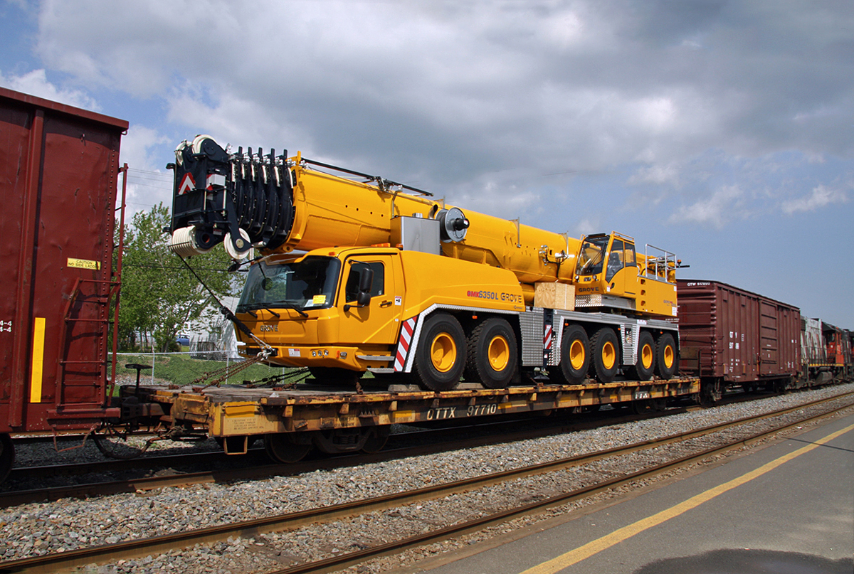A huge Grove Crane on a westbound CN freight, slowly rolling through Bathurst, N.B. May 26, 2012