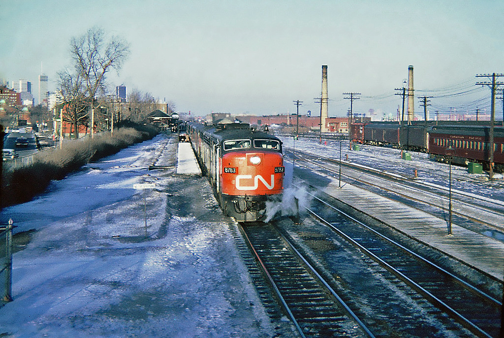 Bound for Toronto CN MLW FPA-4 6783 in charge of the late afternoon CN-CP pool train The International Limited, boarding passengers at Westmount Station March 11, 1965. We can see downtown Montréal in the distance.
