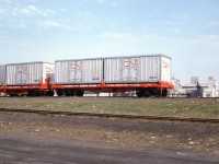 CN and CP experimented with a few different container / intermodal setups in their early years before everything was standardized. This view of the west end of CN's Mimico Yard in 1965 shows CN container flatcar 689011 and a sister loaded with early 20' CN Express Freight containers. In the background, the old National Silicates plant off the north end of the yard can be seen.