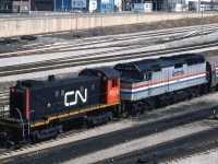CN S13 8515 switches an Amtrak/VIA International Limited consist lead by Amtrak F40PH 363, near Spadina Coachyard as viewed from the Bathurst Street bridge. CN's MLW S13 fleet of 8500's were longtime regulars at Spadina, assembling passenger trains in the yard and shuffling consists to and from nearby Union Station.