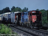 CN GP40 9309 has been sprung from captive service running through the tunnel between Sarnia, Ontario and Port Huron, Michigan and is leading train #272. The train is approaching Aldershot near the site of current day Snake. The second unit is a former Conrail GP38-2 that went into EMD's lease fleet when their lease expired. CN had some on lease for awhile. 

This was one of those days when I was the windshield and not the bug as the westbound got by just in time for me to get the shot. 