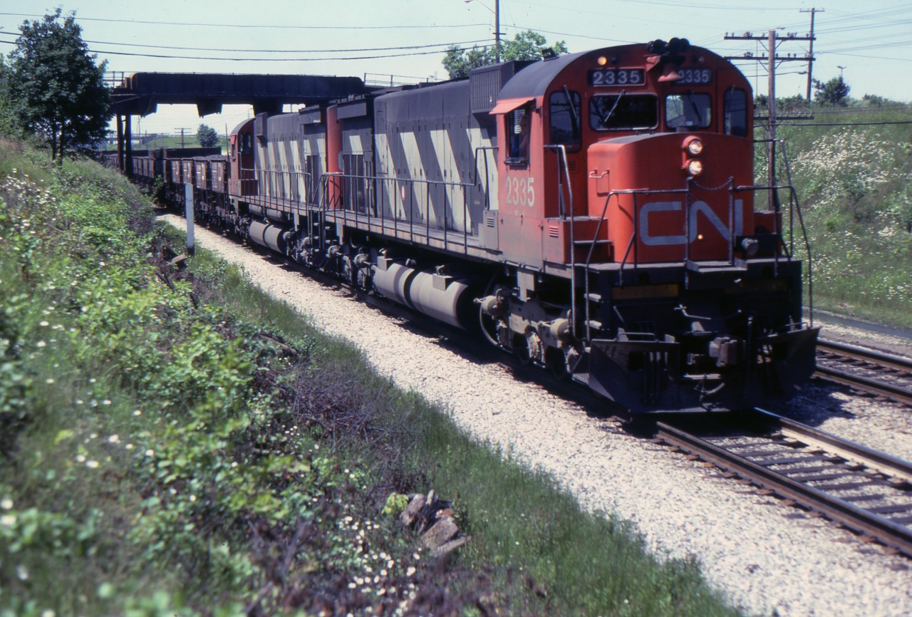 Almost exactly 11 years after my Belleville picture of CN 2335 we see her eastbounud at Brock Street, Whitby. This scene has changed dramatically today as the bridge was replaced and two GO Transit tracks have been added to the right of the CN. The ore cars contained slag which was being used for ballast by both CN and CP. A few years later it was decided that slag was too contaminated to be used this way.
