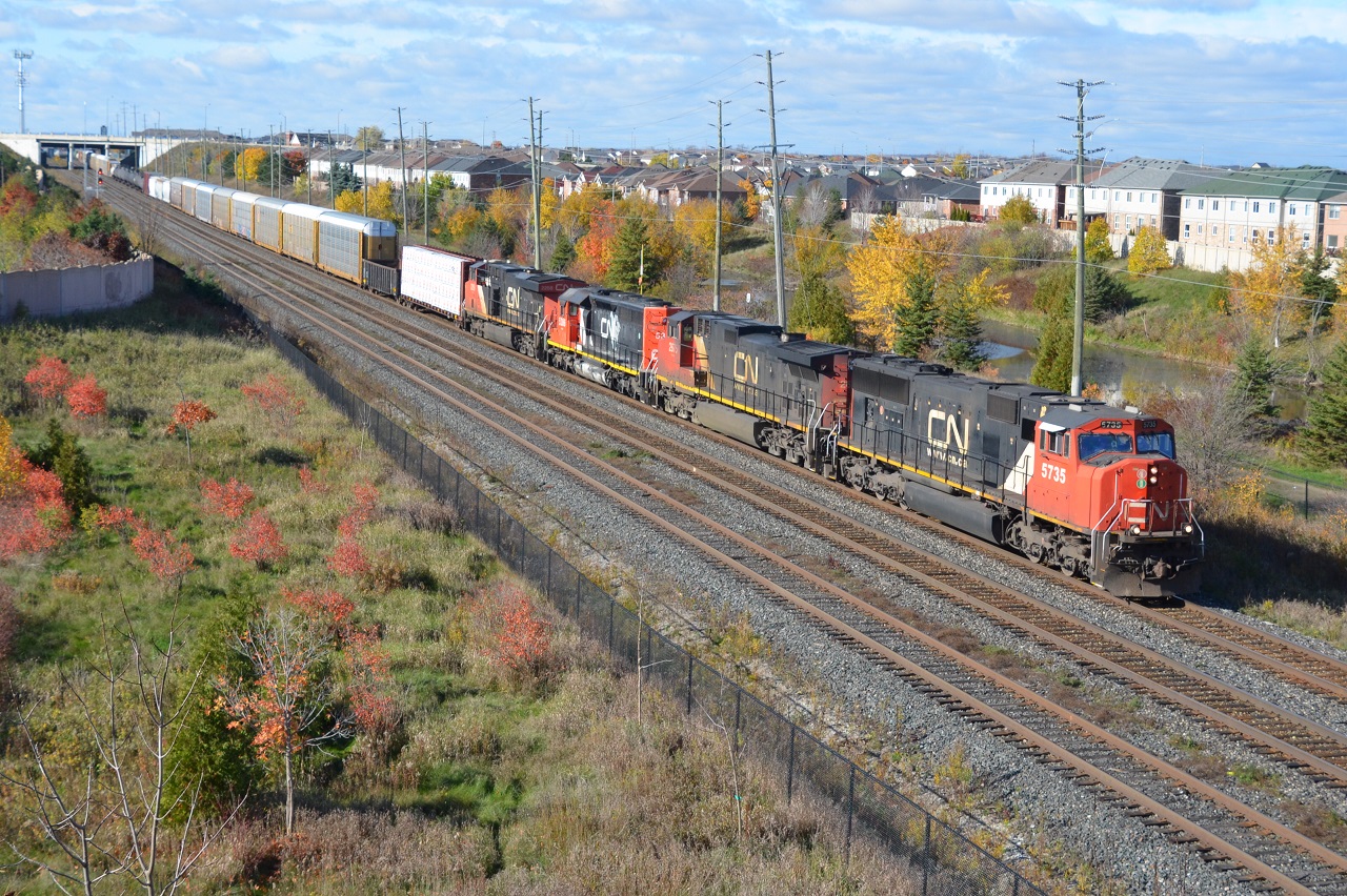 CN M394 passes the Bouvaird mile board with a NA scheme SD40-2 tagging a ride