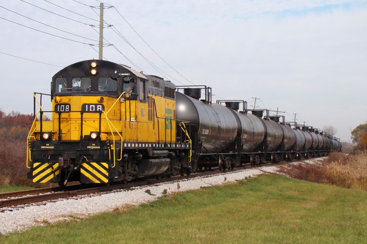 Essex Terminal GP9 #108 has 15 loads of whiskey bound for Diageo Distilleries in Amherstburg as the train is about to cross county road 10 just minutes before entering Amherstburg. The day started by collecting interchange cars then heading out to Ojibway yard with a 21 car train. After switching for a couple of hours in Ojibway alongside another yard job, 108 headed south with their 15 cars ready to switch Diageo. Once complete, the crew will head back North to Ojibway, switch local industry and build their train to take to CN and CP for interchange.