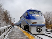 Montreal got its first snowfall of the winter this morning and the trees and the train are covered in sticky snow as AMT 86 arrives at Lasalle Station. In the background a crew takes a break from clearing the station platform as the train passes.