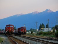 It's a warm and hazy evening in the valley, the final rays of the day glints of the snow capped peaks around Golden as CP 9529 West pauses to fuel after beating the Kicking Horse. It's next challenger: Rogers Pass. In the background on one of the yard tracks CP 8637 West sits awaiting its crew after switching downtown.
