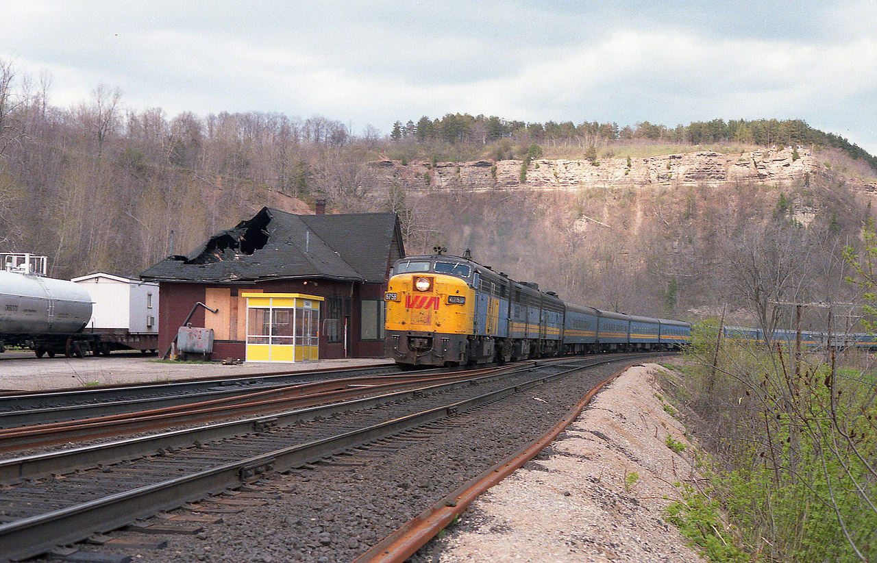 A view with a bit of everything historical. The old Dundas station, on borrowed time as steps to move it and preserve it fell thru, awaits its' demise as VIA #75 with a 'rare' MLW FPA-2u #6758 leader races by westbound. A fire, six months previous, resulted in the gaping hole in the roof was caused by an overheated oil stove that sat in the main waiting room. In front is the temporary Waiting Room for anyone who chose to board the train here. It was more vandalized than used. Behind the lead unit is VIA 6863 and another 'B', unidentified, hauling the typical long #75 of the day. Lead unit #6758 was one of only two units of this model for CN/VIA, the other being 6759. And it is the only survivor, now living as New York & Lake Erie 6758, just south of Buffalo, NY.