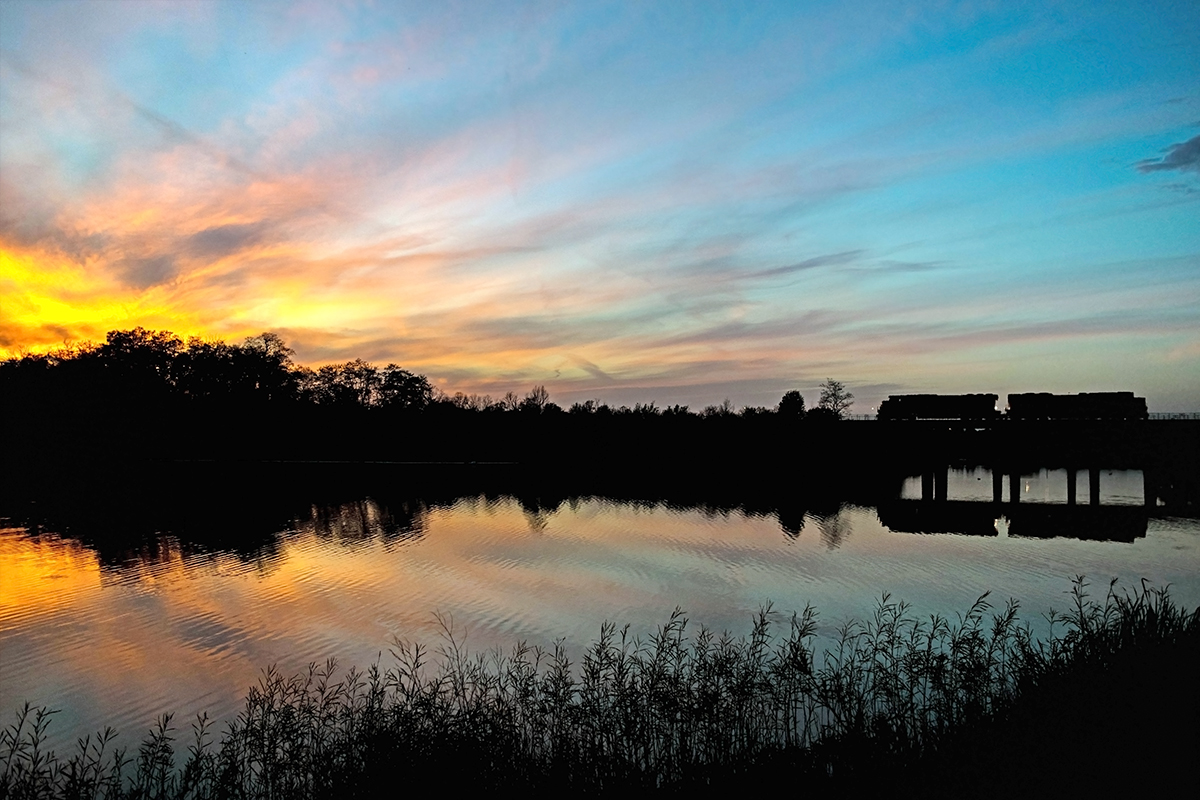 A light move crosses the reservoir on its way to BIT under the dying rays of the summer sun.

It was an uncharacteristically warm start to November, and the morning began with a spectacular sunrise. On my way home from class I looked at the clouds in the sky and hoped that, just maybe, the sunset would be even half as breathtaking. As soon as I reached my house, I grabbed my camera, tore off on my bike and raced to this spot. The sunset was enough of a treat on its own, so I couldn't believe that my luck could be any better. That's when I heard the distant rumble of these engines coming my way.

I haven't been very active on here lately due to changing interests in my life and being so busy with university, so thanks for welcoming me back for a little while! All the best.