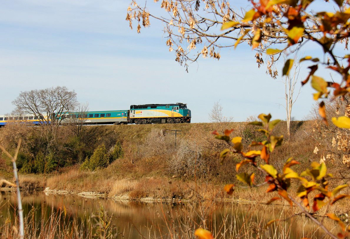 A very late VIA 84 (time around 10:35), framed by the last remaining fall foliage, heads east towards Toronto approaching the Grand River and the community of Breslau, just east of Kitchener.
