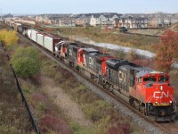 CN train 399 passes through new Milton suburbs only a few hours ahead of numerous "trick or Treaters"taking to the streets. Tucked in behind the CN power is GMTX 724, a former IHB SW900.