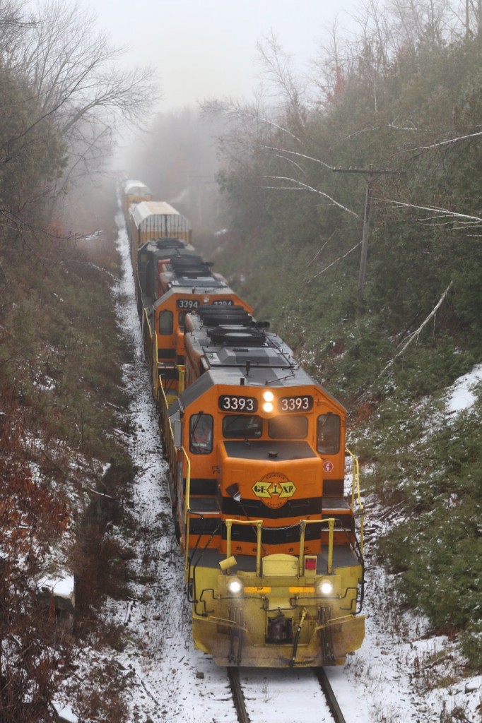 Well it's one month till Christmas eve and I finally get my first snow of the season, although not much. Here GEXR train 431 rolls through light fog at Limehouse with the power in run 8 as it digs into the gradual grade up the Niagara Escarpment on wet rails. today there would be no complications.