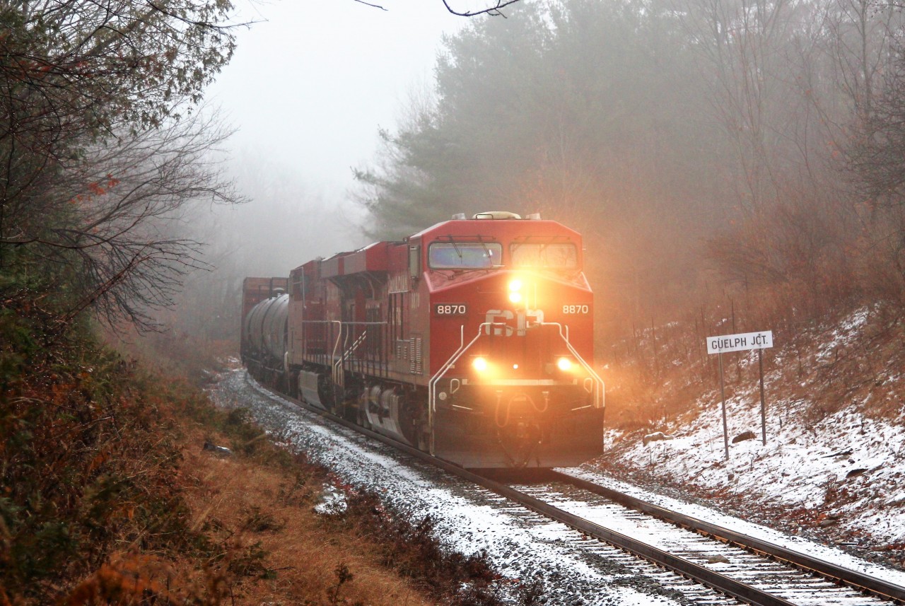 Through the rain and the fog comes CP 246 led by CP 8870 with CP 8790 as they past the Guelph Junction CTC sign on their way to Kinnear yard.