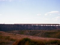 This bridge is of such massive proportions it just seems to swallow up a 6 unit, 30-40 car train like it was an N scale on an HO layout. Just to the west of Lethbridge, it spans the Oldman River and Valley to the tune of 5,327 feet, and at its highest point 314 ft above the valley floor. Even if this is a westbound train, complete with caboose, it made for a spectacular sight to witness. All six units up front are SDs.