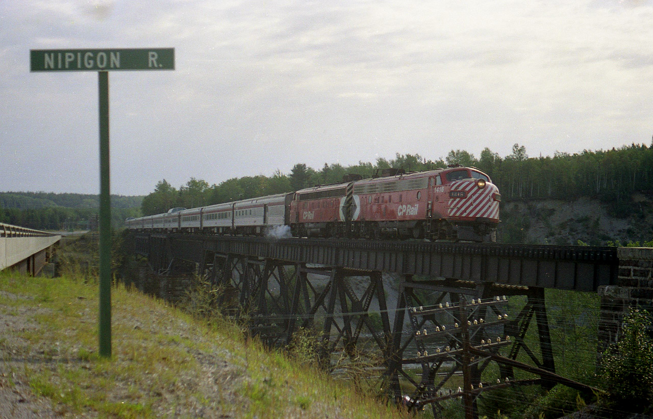 CP 1416 and 1410 power the Canadian westward over the Nipigon River bridge in this late morning image taken from the side of Highway 17, just over 40 years ago as of this posting. Back then this train was daily, rolling thru town around the noon hour when on time. CP 1410 sold to VIA, overhaul completion 2/28/79 at Ogden, and CP 1416 also to VIA, overhaul completion 11/30/78. They became VIA 6558 and 6564.