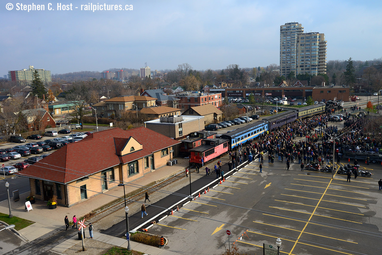 Lest we forget on this sombre Remberance Day in 2015, a large crowd has gathered at the Waterloo cenotaph for a memorial ceremony remembering those who have served and paid the ultimate price defending our freedom. A special train for veterans and their families was brought down to shelter them from what was promising to be a rainy day, but the rain held off. I don't think this is happening again this year - the WCR website does not allude to this event occuring - special permission was granted by Grandlinq for the 2015 move - while the LRT isn't operating yet - this time next year it will be.

In one of my posts earlier this week, I posted a photo at the 1990's buitl WSJR station. This is the real ex Grand Trunk station, built in 1910 and now is a Men's clothing store - Paul Punchers. Punchers also has a ex CNR caboose on-site. 
Photo notes: NOT a drone photo.