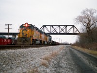B&0 4801, C&0 3885 and C&0 4828, the power for this days "Nanticoke Steel Train", is shown here on the CP/TH&B STEEL train's first month of operation over the route south from Brantford. The high bridge in the photo is the old LE&NRR structure (Lake Erie & Northern). Because it is out of commission, TH&B was running the leased Chessie units down their old track, out the west end of their wye at Waterford, then backing down the CASO eastward, crossing over, and up the south side. (That connector is out of sight on the other side of the bridge on the right) and this enabled the train to continue on southward. The intricate manoeuvre was all because the bridge had been out of service for many years. CP eventually redecked the bridge but then the train was cancelled due to track washout in Brantford anyway. Currently it is used as part of the LE&N Hiking Trail. On this day I have forgotten why I was able to photograph this power moving lite. I assume cars were being set off or picked up, as there was room on the west wide of the wye for a dozen or so cars.