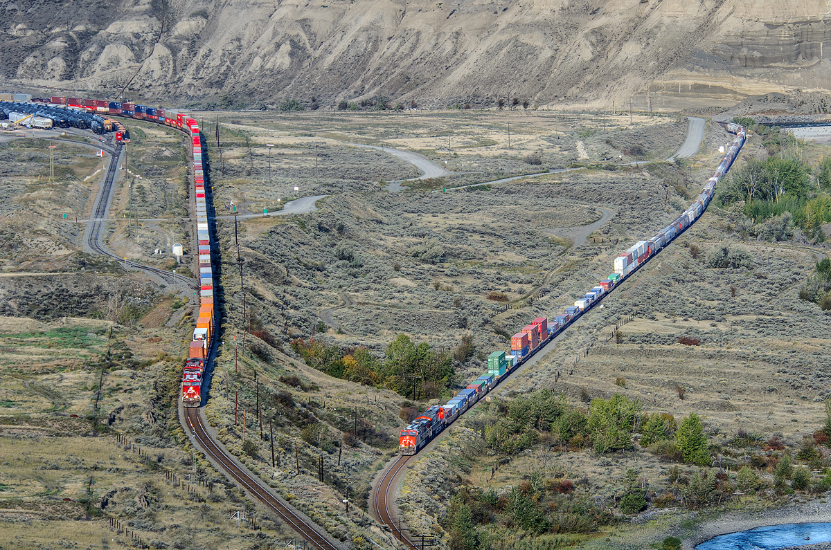 The race is on!! With both trains speeding towards a crew change at Kamloops, CP's Vancouver-Toronto hotshot 100-22 is seen at left while CN's Vancouver-Edmonton M31051 21 is seen at right. They're heading eastbound along the shores of the Thompson River just east of Ashcroft, BC.