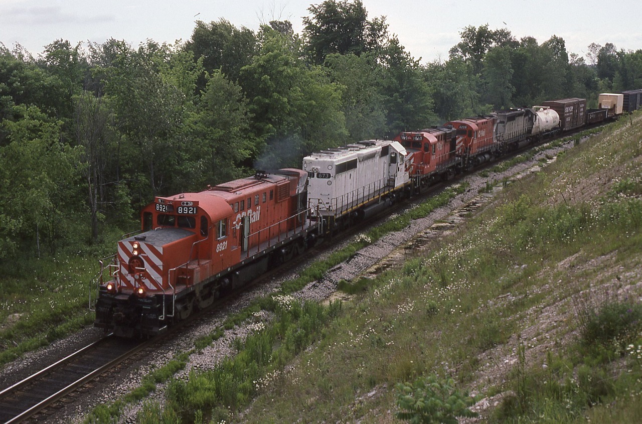 A nice mix of power handles an extra east at Ajax. CP 8921 was no longer in captive service in Toronto And was just another road unit. The 2 ex KCS SD40-2,s had just been purchased and awaiting there red CP Rail decals. It may not have been sunny for the perfectionists but ? ?  8921 is preserved in St Thomas Ontario at the Elgin county railway museum.