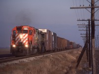 CP Extra 5550 West hustles across the flatlands of Essex County with an in-identified QNSL SD40 trailing.