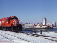 "South of the Border". CP 1588 is todays assigned Boat Job engine as NS tug 'R.G. Cassidy' heads light upriver to the CN dock. Across the river can be seen Detroit's Michigan Central Station, the US Post Office building and Tiger Stadium. Windsor, Ont. Dec 28th 1985.