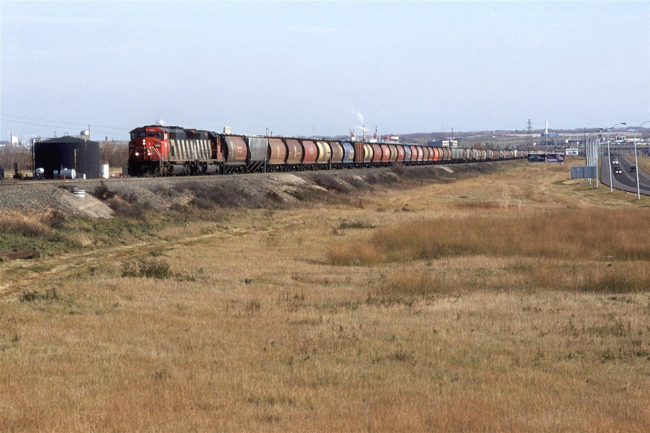 A grain train arrives in Edmonton. The tank at far left is for a contaminated water collection system for the the old Domtar creosote plant.
 On the horizon, above and to the left of the train is Celanese and the colourfull stacks belong to a Fiberglass plant, I believe.