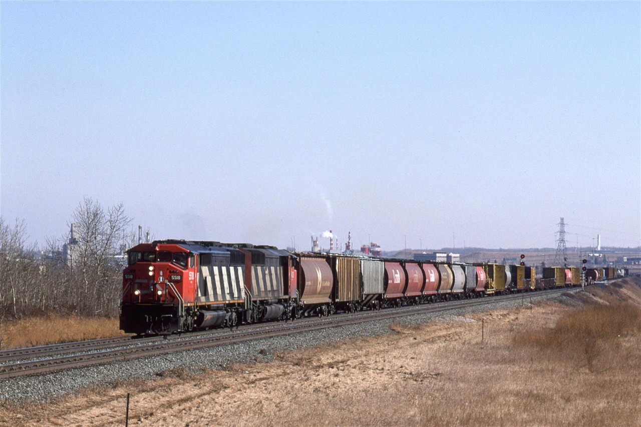 Train #351 is a "Dimensional" train that runs from Winnipeg to Vancouver. Here, it is in East Edmonton, just after crossing the North Saskatchewan River. For leaders, we have a SD60F and a SD50F.
My vantage point is somewhat elevated. I believe that I climbed onto a working platform on a low billboard. No ladders or rope were requited - just a little gymnastics that I would be hard-pressed to do today.