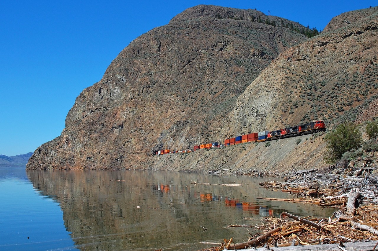 An eastbound Intermodal is reflected in Kamloops Lake as it approaches Kissick behind CN 2707.