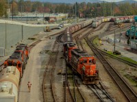 <b>Yard jobs meet in Lynn Creek Yard.</b> SD40u 6023, with the help of SD40-2W 5265, pulls a cut of loaded grain hoppers out of track 50 to be taken over to the elevators and dumped. To the right, GTW 5819 waits patiently with a geep cousin to get into the larger part of the yard. 