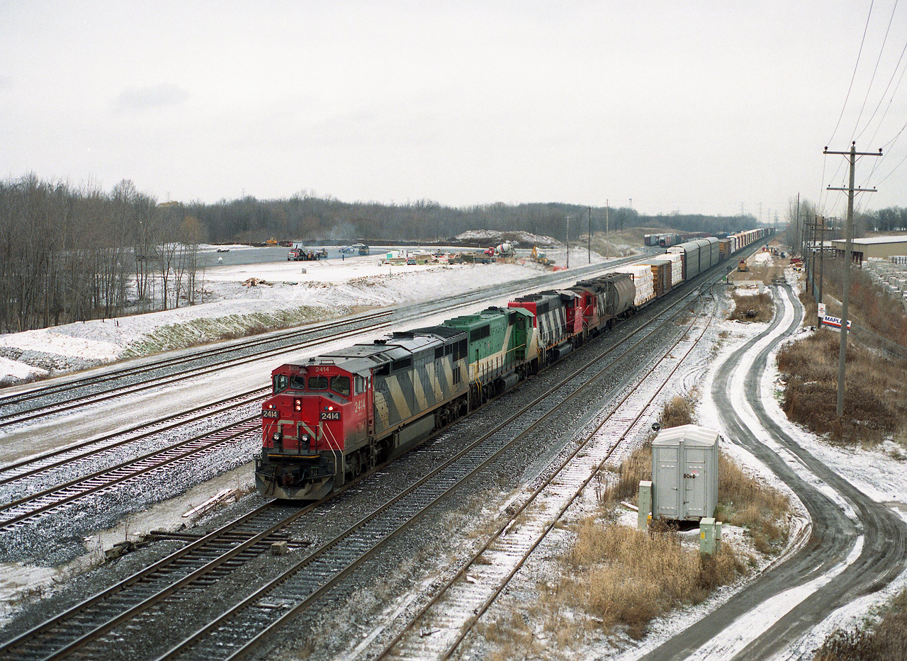This is a familiar location for the train junkies of the Golden Horseshoe area. I am by the Waterdown Rd bridge shooting north, with the under-construction Aldershot GO facility in the background. Westbound CN 2425 is assisted by 9676 (x-GO 709), 9401 and 4537. Note location of the Aldershot yard back then...way down the line.It has expanded considerably since this photo. Great opportunity for a very interesting Time Machine followup, only problem is, the area has expanded to the point it is almost dangerous wandering along the side of the road there; not the quiet of days past.