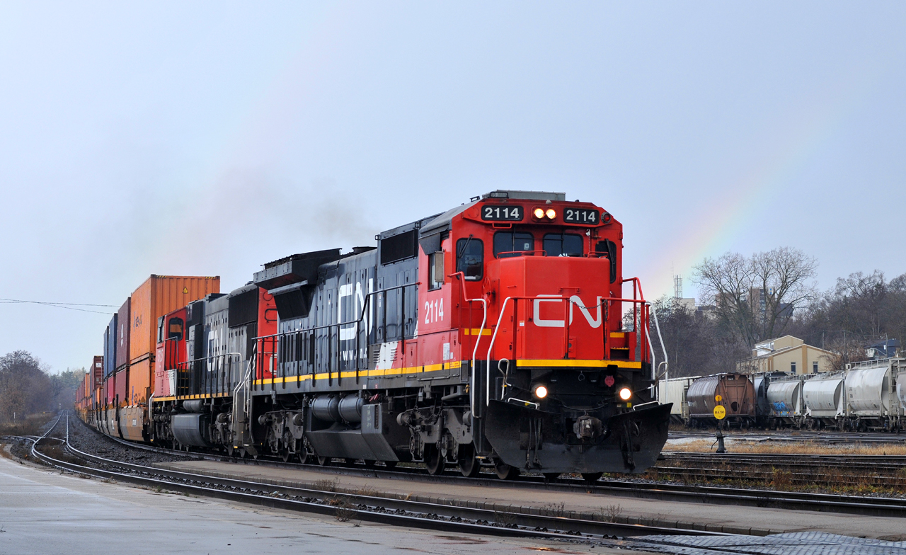 In a brief break from the downpour of rain, we see Q14891 29 sneaking under the double rainbows with CN 2114, CN 5725, and 139 cars